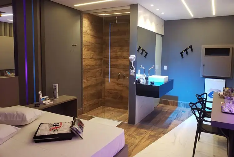 Metragem ampla da Suíte Júpiter com circulação fluida, bancada moderna e ducha relaxante